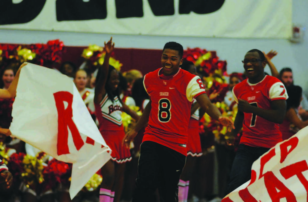 Senior Brian Jones runs through the Raider Nation banner at Homecoming Fest Oct. 11. Students and community members filled the bleachers while the Raiderettes, cheerleaders and band performed. The Fest was a success, with T-shirts, required for admission to the event, selling out days before, requiring a second order. Although the Fest was not formally called a pep rally, its characteristics embodied one.